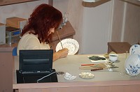  Here we see an under-glaze painter.  The porcelain has been fired once to make it hard, but no glaze has yet been put on it to give it the clear finish.  This paint is the signature Meissen blue and it soaks into the porcelain and cannot be chipped off at all.  When a piece such as a flower is given an entirely different color, such as red, green or blue, this is when that color is added.